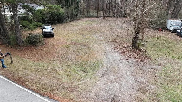 a view of a yard with plants and trees