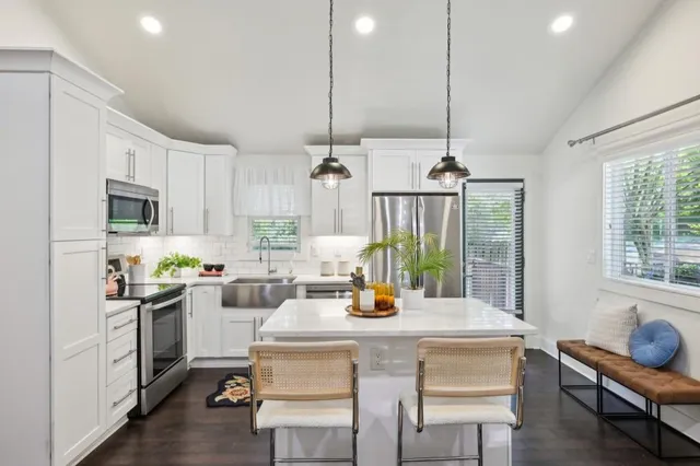 a kitchen with a sink a stove and chairs