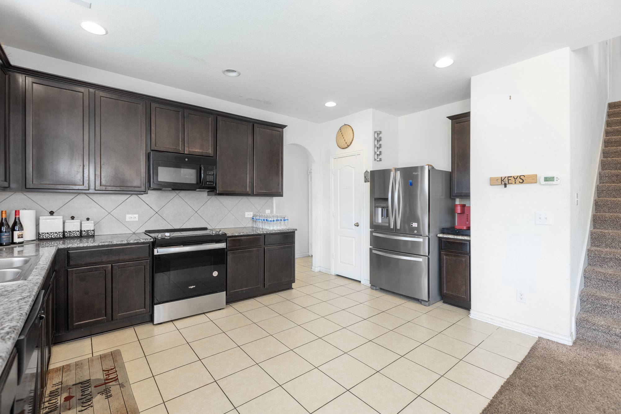 263 Joseph Drive Buda, TX 78610 - Photo 12 of 27 a kitchen with stainless steel appliances granite countertop a refrigerator sink and cabinets