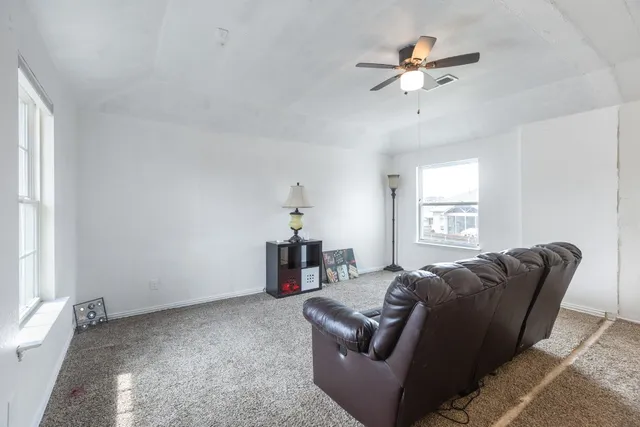 a living room with furniture a ceiling fan and a window