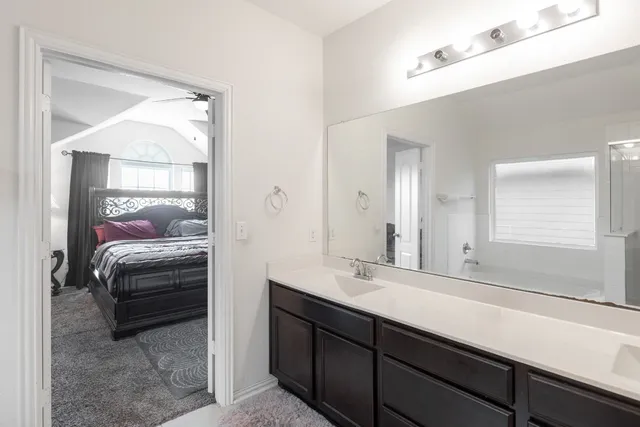 a en suite bathroom with a double vanity sink and a mirror
