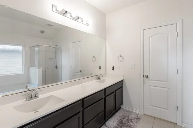 a bathroom with double vanity sinks and a mirror