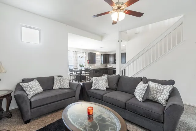 a living room with furniture and a ceiling fan