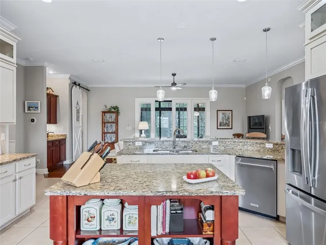 a kitchen with stainless steel appliances granite countertop table chairs and a wooden floor