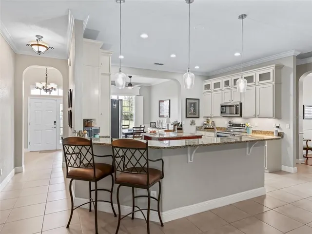 a living room with furniture a flat screen tv and kitchen view