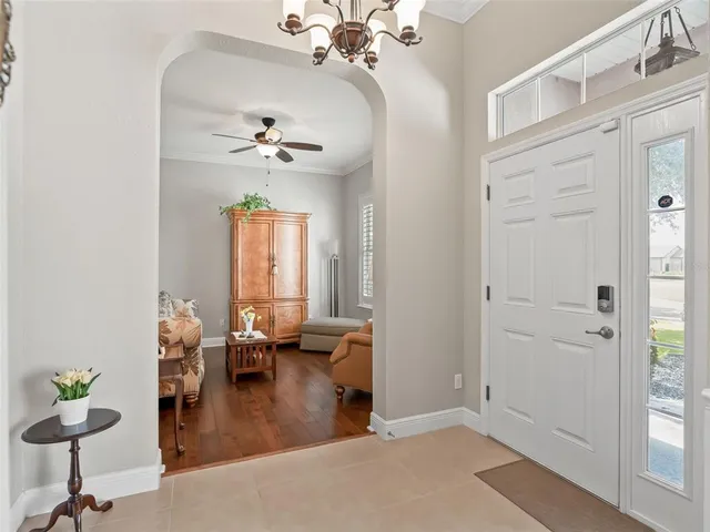 a living room with furniture a chandelier and a table