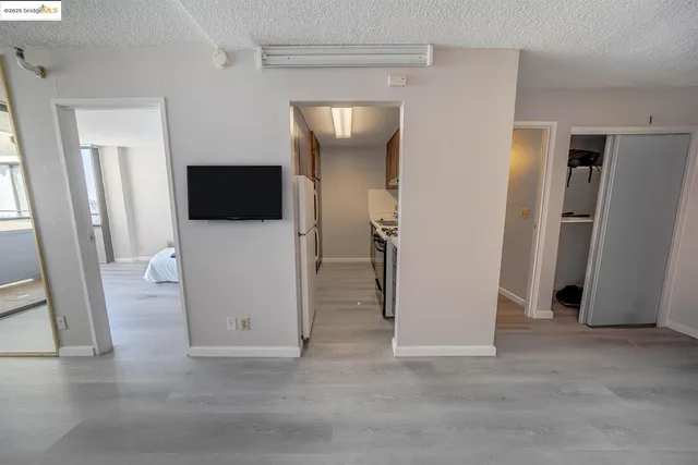 a view of a livingroom with an empty space and a refrigerator