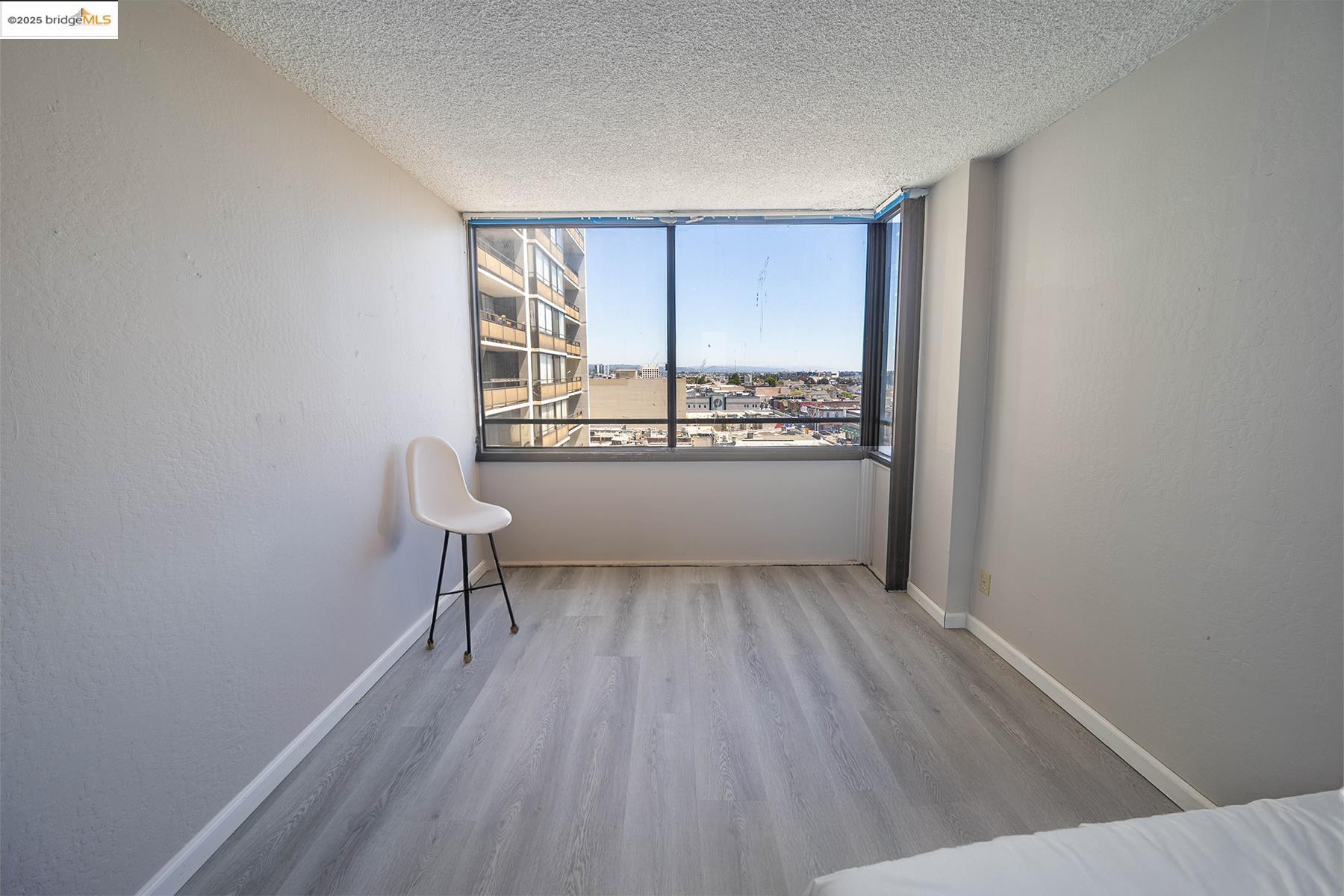 801 Franklin Street, Unit 819 Oakland, CA 94607 - Photo 5 of 9 a view of a room with wooden floor and a window