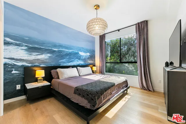 a bedroom with a bed and a chandelier