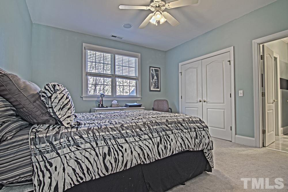 120 Bayleaf Drive Raleigh, NC 27615 - Photo 18 of 25 a bedroom with a bed and a chandelier