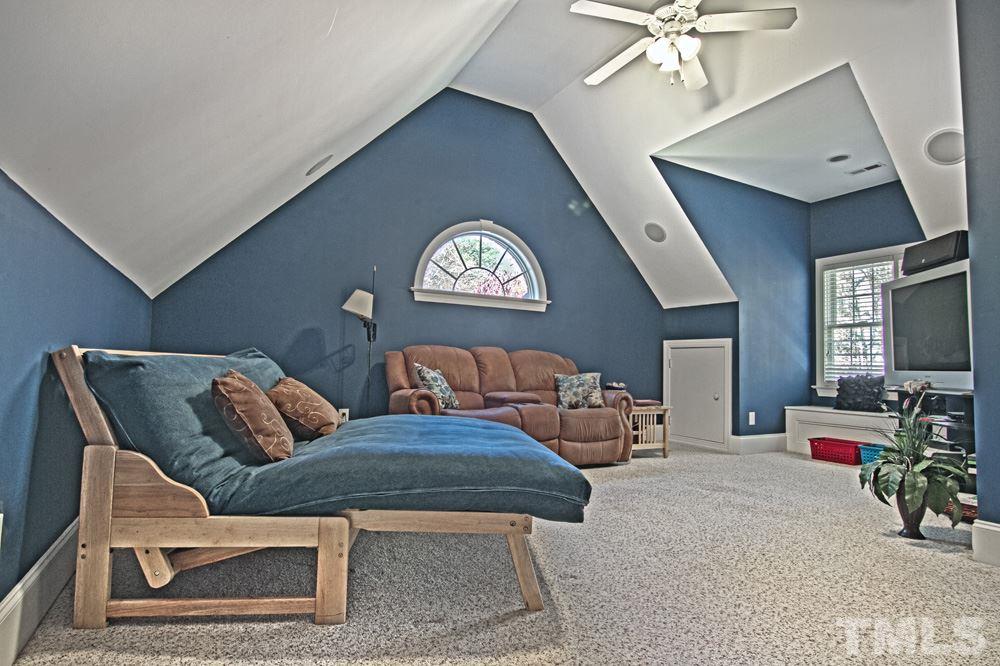 120 Bayleaf Drive Raleigh, NC 27615 - Photo 22 of 25 a living room with furniture a chandelier and a flat screen tv