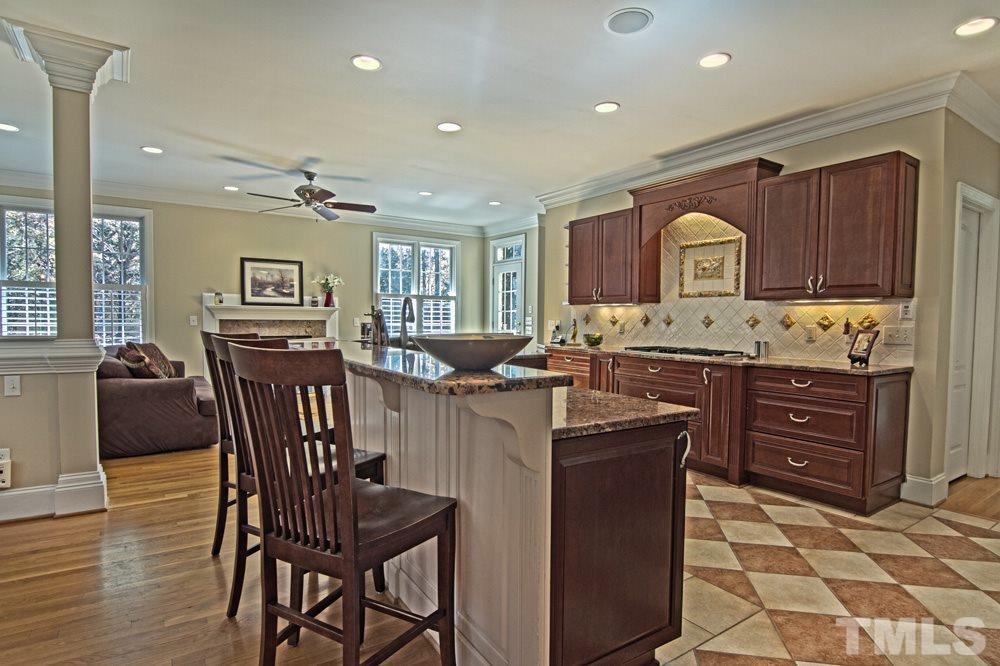 120 Bayleaf Drive Raleigh, NC 27615 - Photo 9 of 25 a kitchen with stainless steel appliances kitchen island granite countertop a stove a sink a dining table and chairs