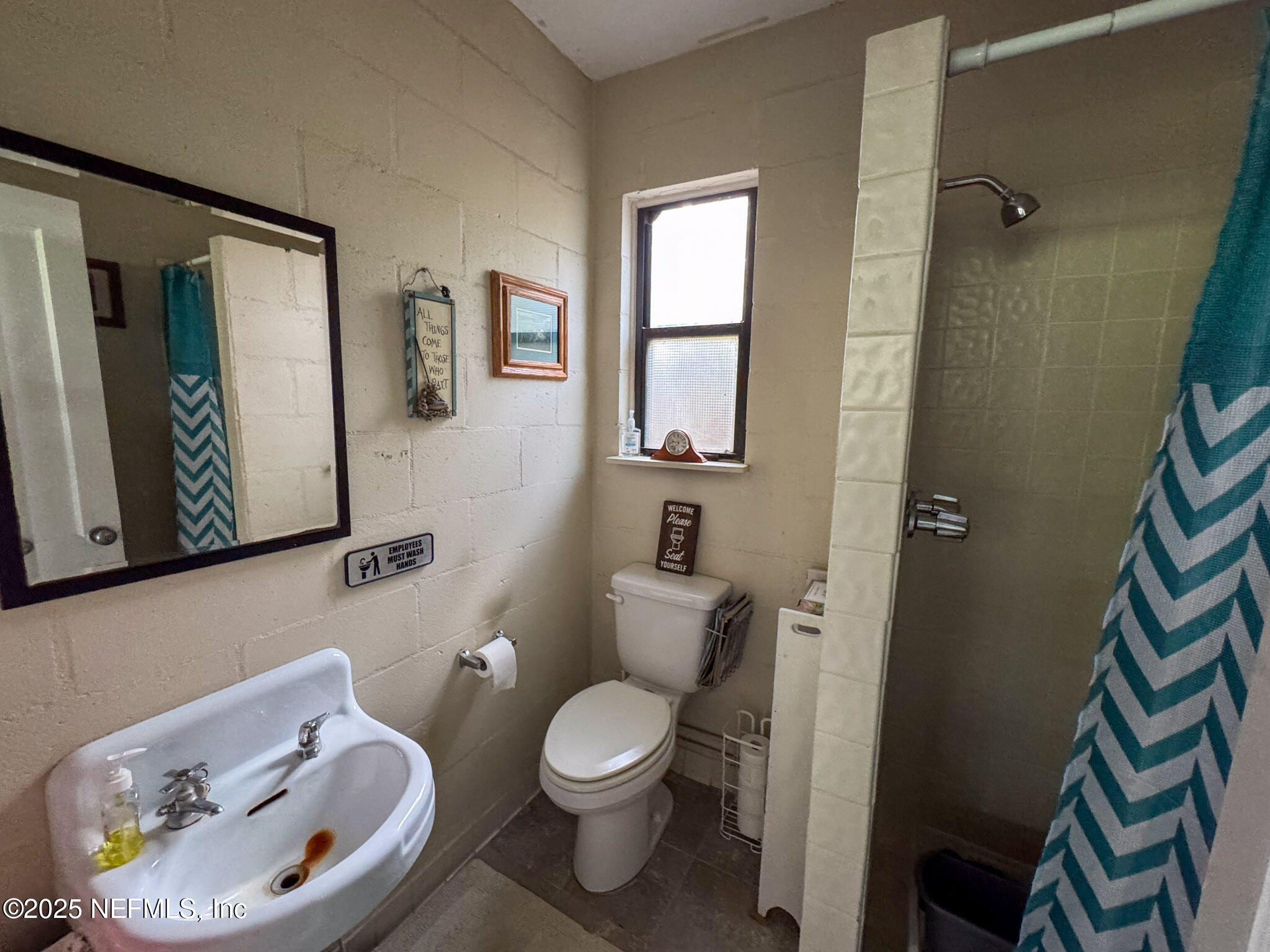 8160 Alderman Road Melrose, FL 32666 - Photo 14 of 15 a bathroom with a toilet a sink and a mirror