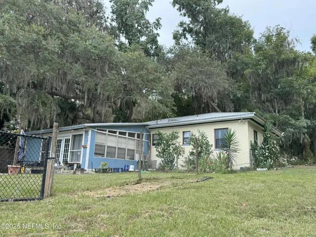 a view of a house with yard and sitting area
