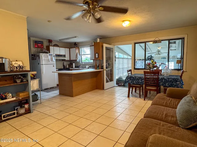 a living room with furniture a flat screen tv and a dining table
