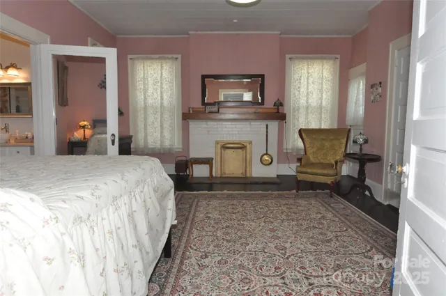 a spacious bedroom with a bed a fireplace and a television