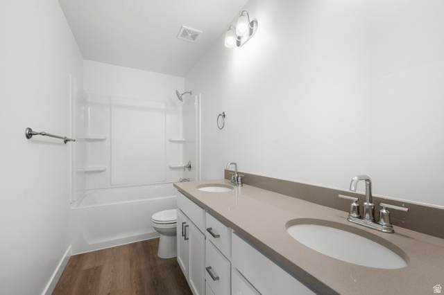 1554 Pheasant Road Eagle Mountain, UT 84005 - Photo 24 of 29 Full bathroom featuring double vanity, dark wood-style flooring, and bathing tub / shower combination