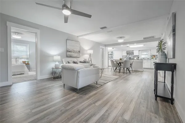 a living room with furniture and a wooden floor
