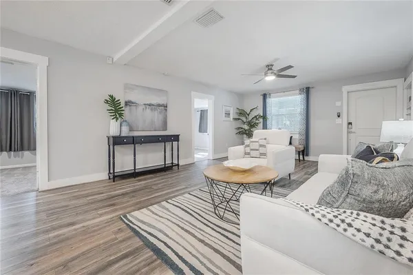 a living room with furniture and a wooden floor