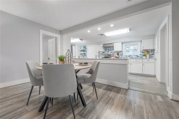 a kitchen with a dining table chairs and white cabinets