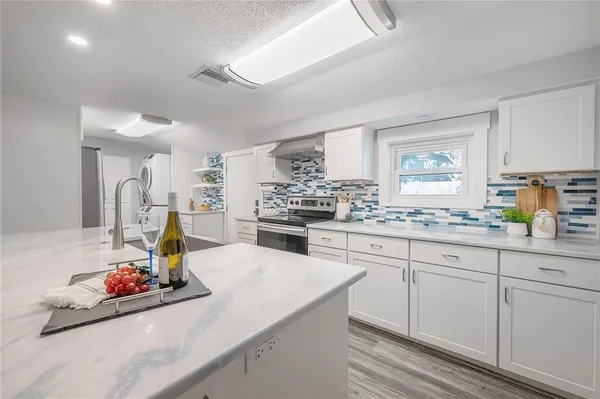 a kitchen with sink refrigerator and stove
