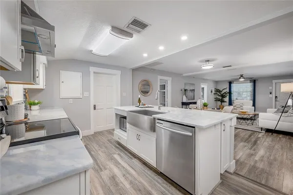 a large white kitchen with stainless steel appliances granite countertop lots of counter top and sink