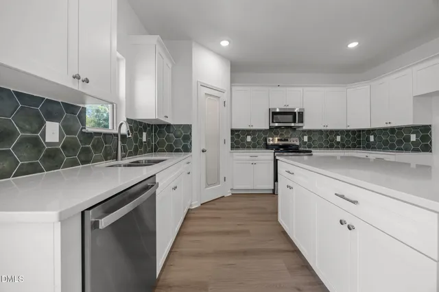 a large white kitchen with cabinets