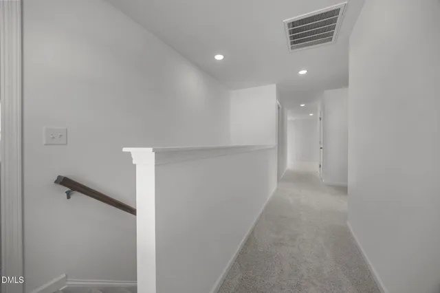 an empty room with wooden floor ceiling fan and windows