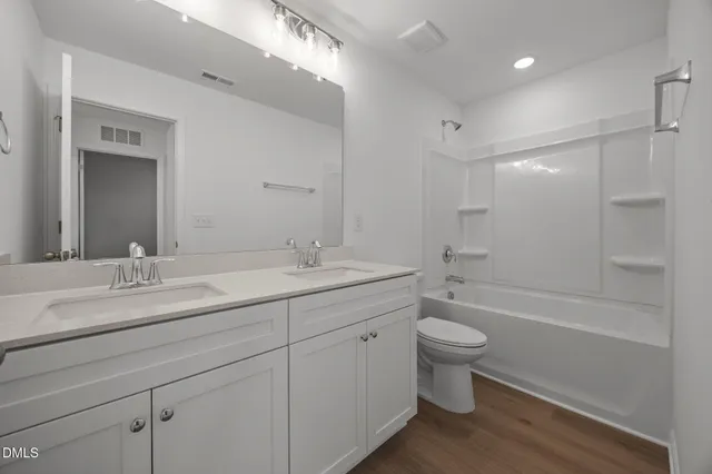 a bathroom with a double vanity sink toilet and shower