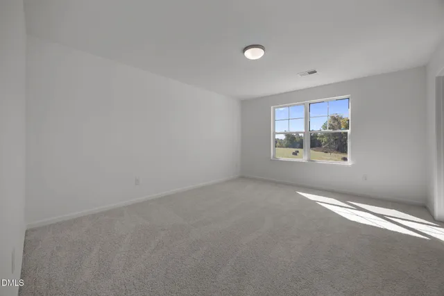 an empty room with windows and air conditioner vent