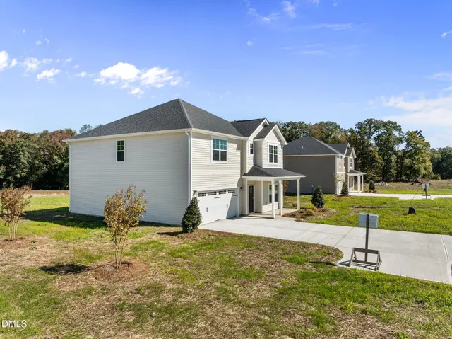a front view of house with garden and trees