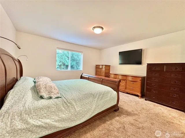 a bedroom with a bed and a flat screen tv