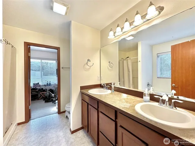 a en suite bathroom with a double vanity sink and a mirror