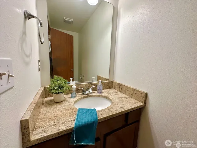 a bathroom with a granite countertop sink and a mirror