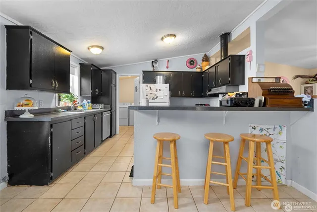 a kitchen with stainless steel appliances granite countertop a sink and a refrigerator