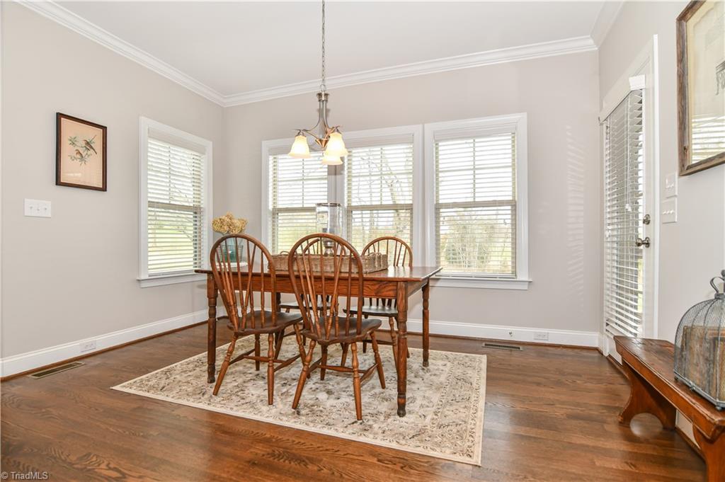 7434 Princess Ann Court Rural Hall, NC 27045 - Photo 13 of 30 Dining room is framed by windows, and leads to screened porch for entertaining outdoors.
