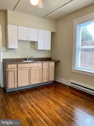 a kitchen with stainless steel appliances granite countertop a sink a stove cabinets and wooden floor