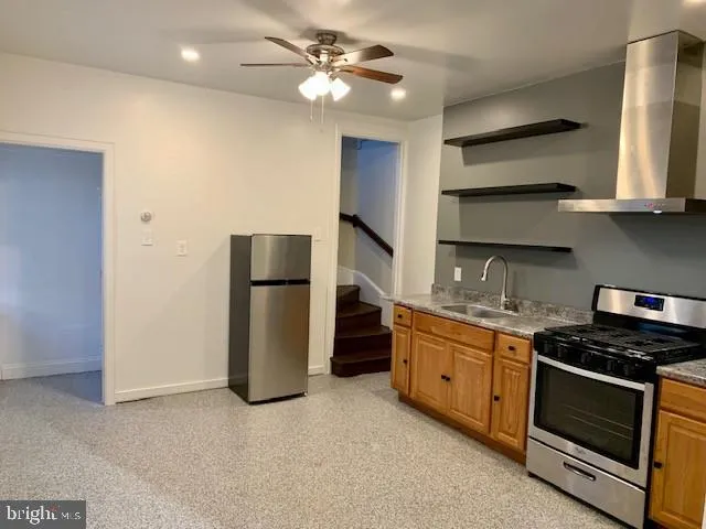 a kitchen with stainless steel appliances a stove a sink and a refrigerator