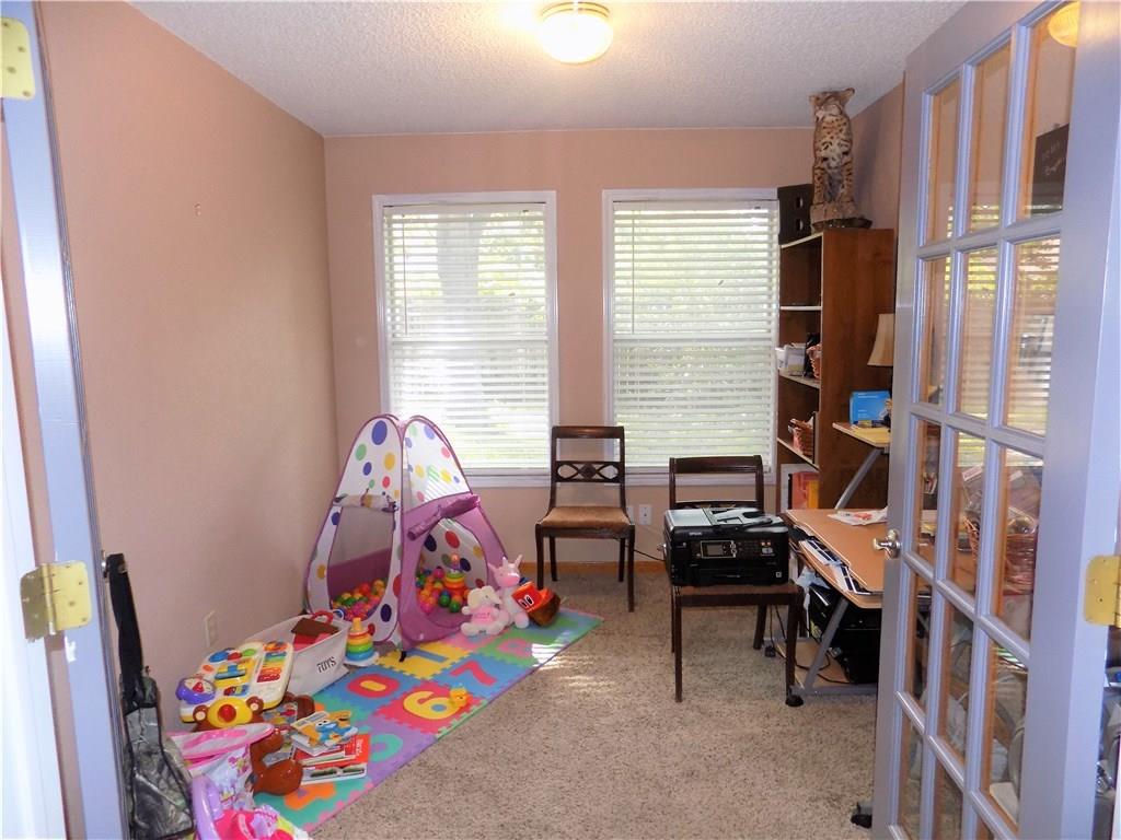 2306 Raintree Path Round Rock, TX 78664 - Photo 7 of 15 Carpeted room with two windows, a built-in bookshelf, and French doors featuring multiple glass panes