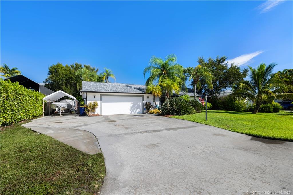 5279 Southeast Horseshoe Point Road Stuart, FL 34997 - Photo 23 of 34 a front view of a house with a yard and garage