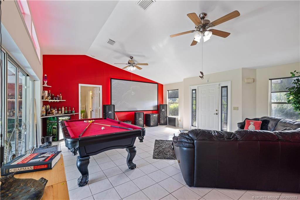5279 Southeast Horseshoe Point Road Stuart, FL 34997 - Photo 5 of 34 a living room with furniture gym equipment and a chandelier