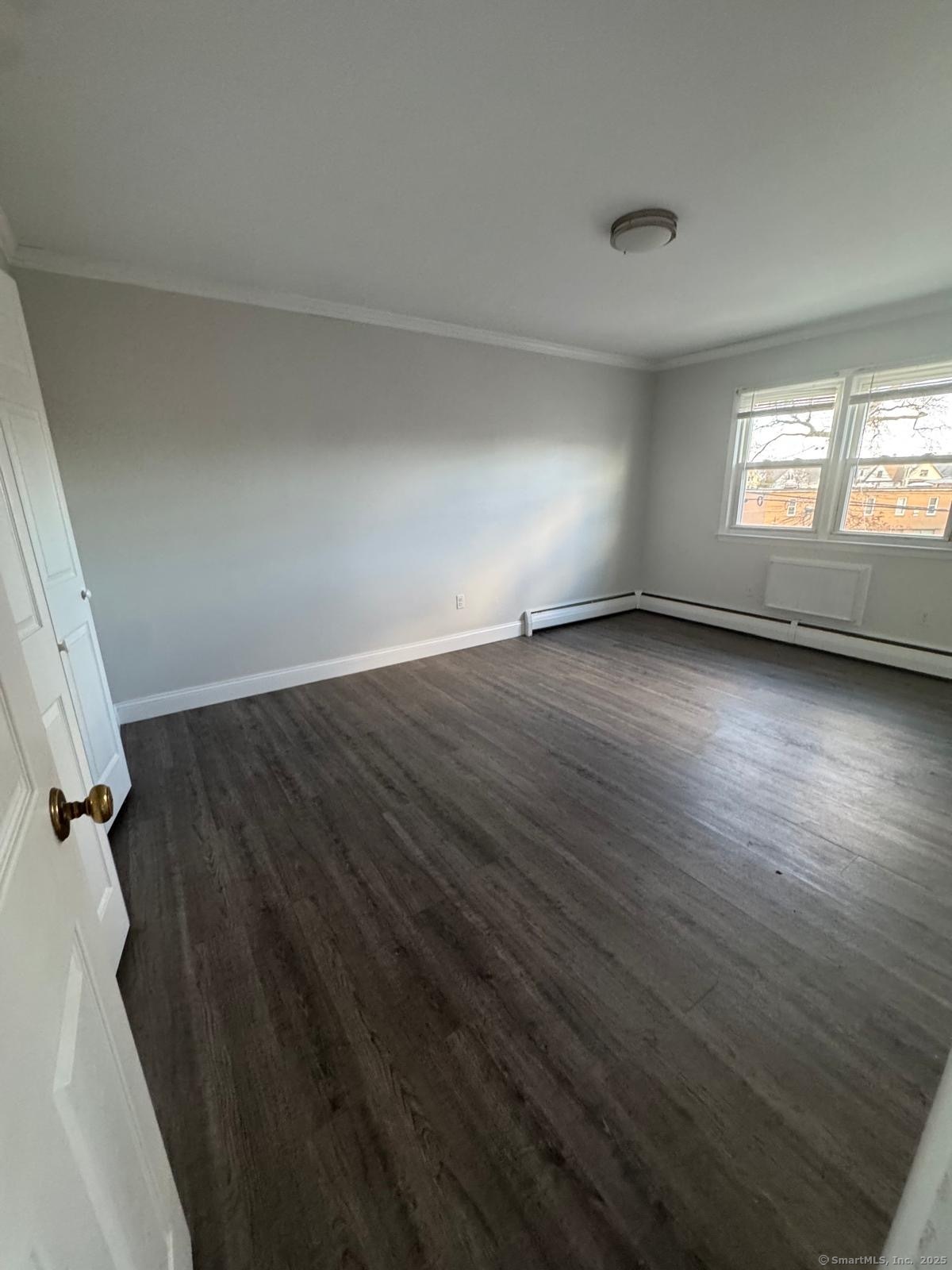 191 Oak Street, Unit B6 Bridgeport, CT 06604 - Photo 3 of 15 an empty room with wooden floor and windows