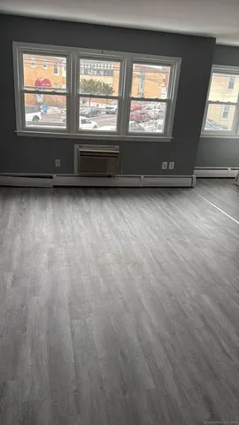 an empty room with wooden floor and entrance