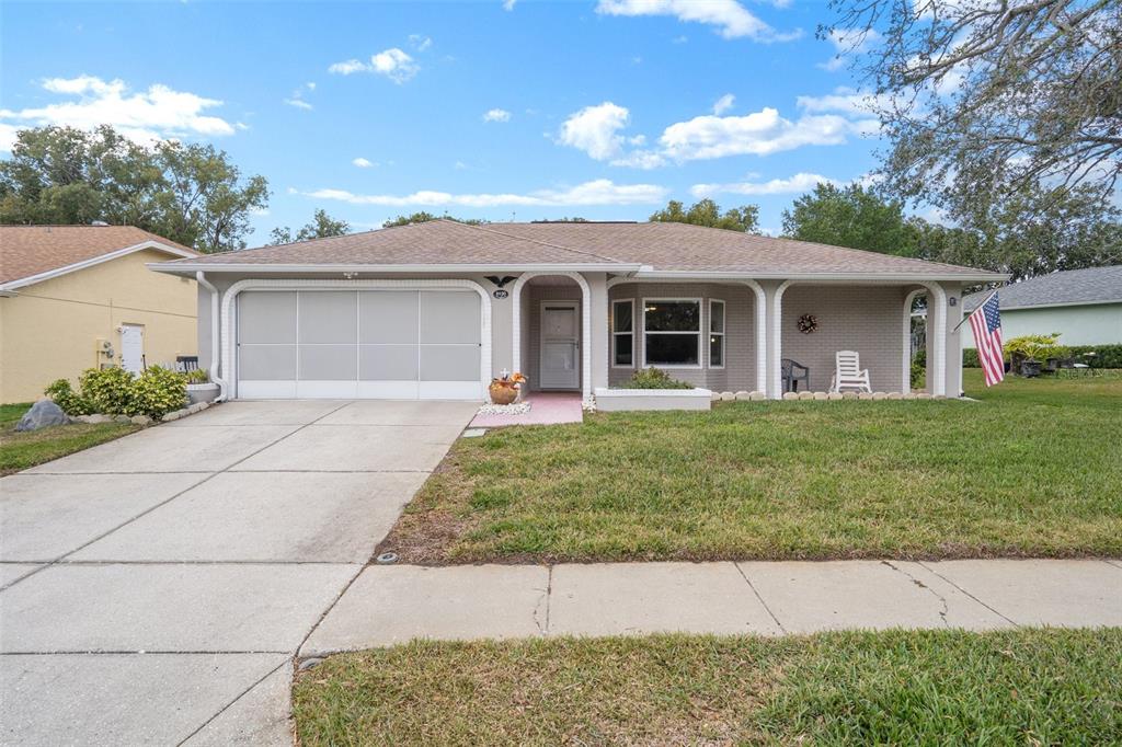 8130 Merrimac Drive Port Richey, FL 34668 - Photo 1 of 53 a front view of house with yard and trees around