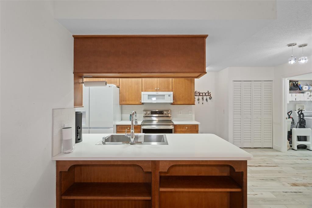 8130 Merrimac Drive Port Richey, FL 34668 - Photo 17 of 53 a kitchen with a sink a stove and wooden floor