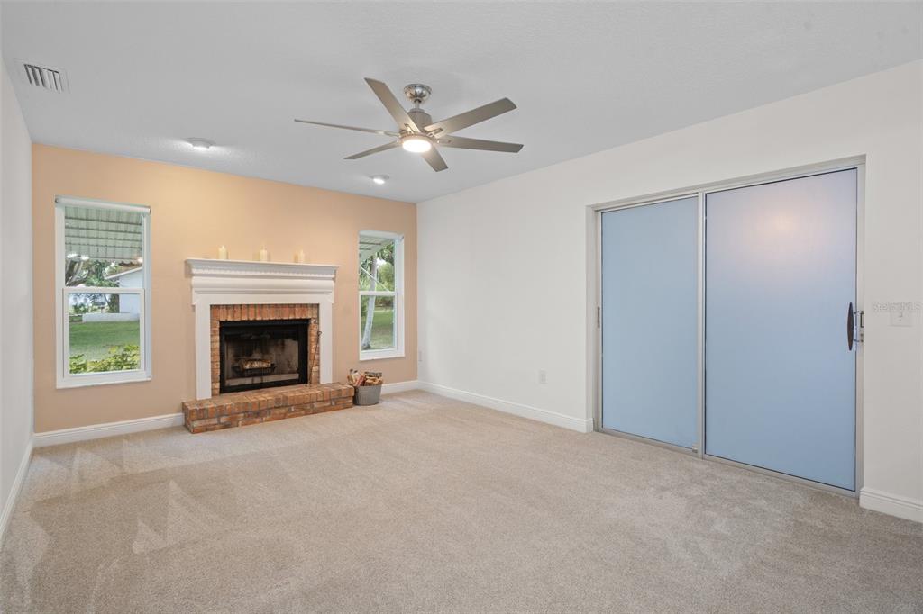 8130 Merrimac Drive Port Richey, FL 34668 - Photo 20 of 53 a view of an empty room with a fireplace and a window