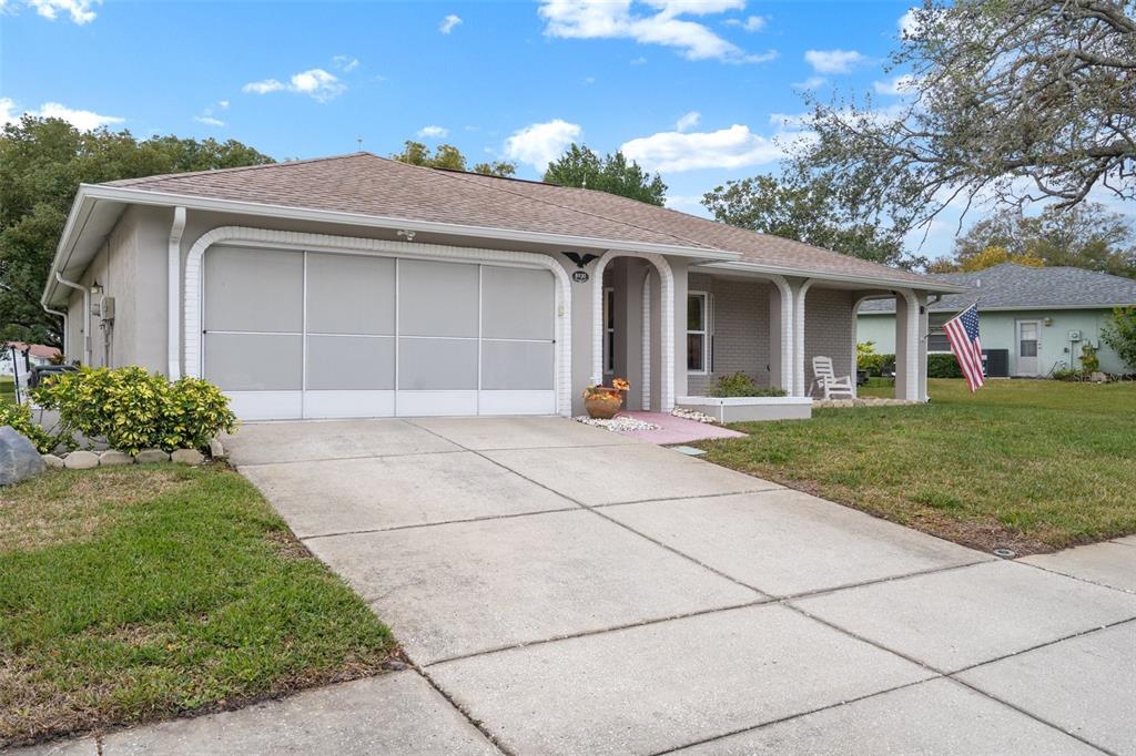 8130 Merrimac Drive Port Richey, FL 34668 - Photo 2 of 53 a front view of a house with a garden and plants