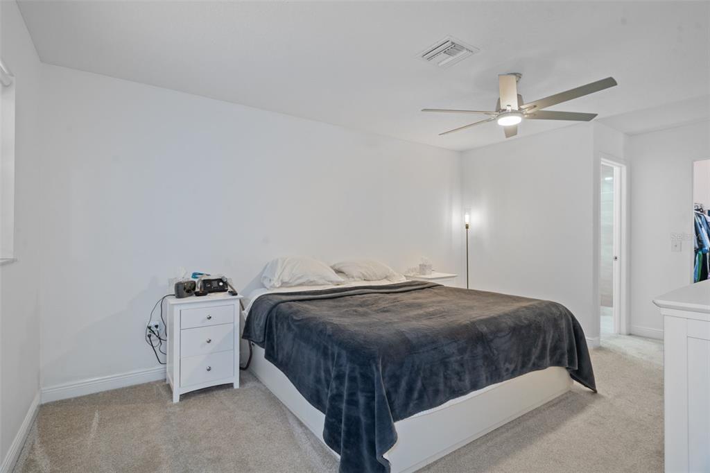 8130 Merrimac Drive Port Richey, FL 34668 - Photo 23 of 53 a bedroom with a bed and a ceiling fan