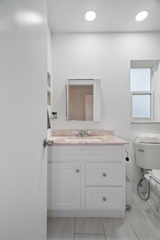 8130 Merrimac Drive Port Richey, FL 34668 - Photo 27 of 53 a bathroom with a granite countertop toilet sink mirror and vanity
