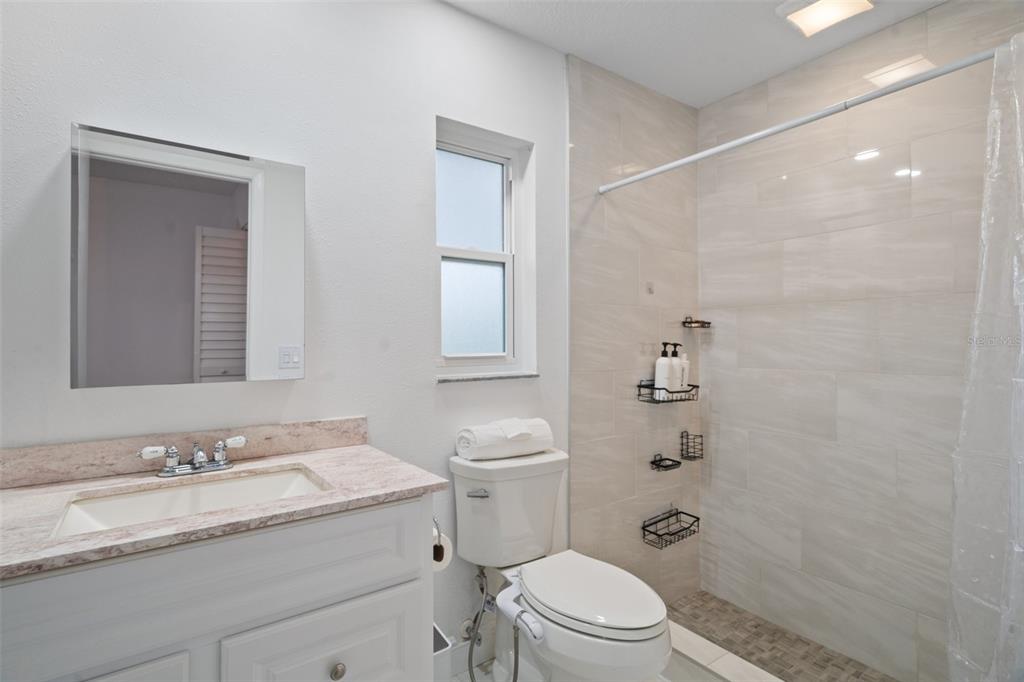 8130 Merrimac Drive Port Richey, FL 34668 - Photo 28 of 53 a bathroom with a granite countertop sink a toilet and shower